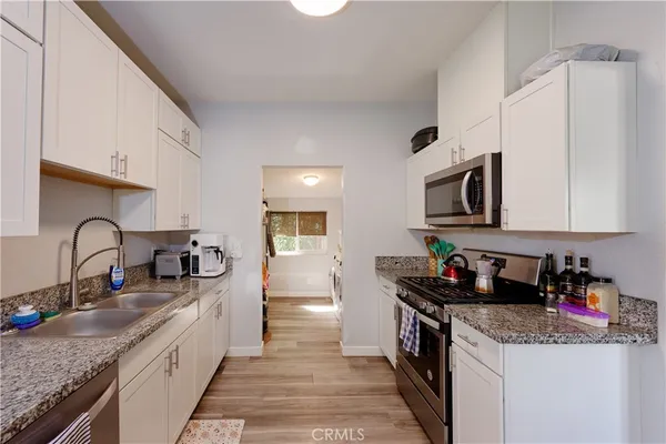 a kitchen with stainless steel appliances granite countertop a sink stove and cabinets