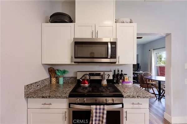 a kitchen with stainless steel appliances a stove a microwave a sink and cabinets