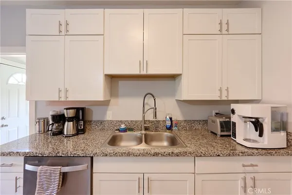 a kitchen with granite countertop a sink and cabinets