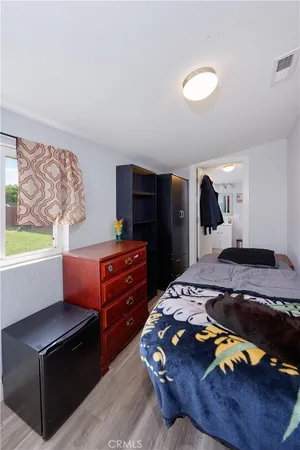 a bedroom with a bed and a dresser in it