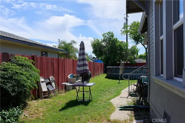 a view of a chair and table in backyard of the house