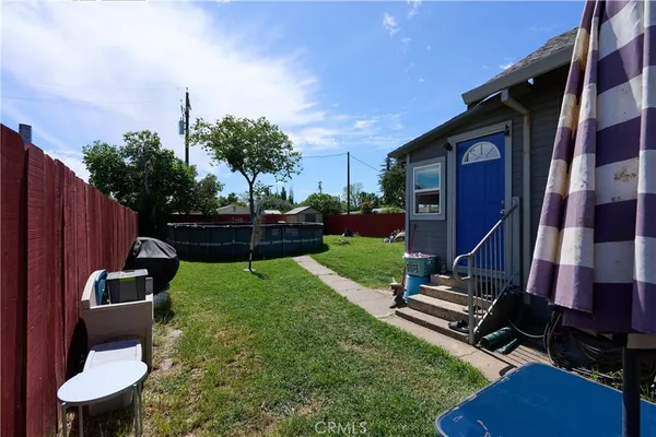 a backyard of a house with table and chairs
