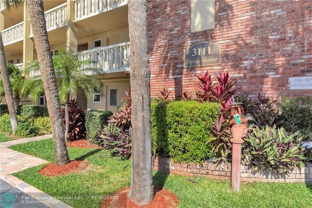 a view of a house with brick walls and flower plants