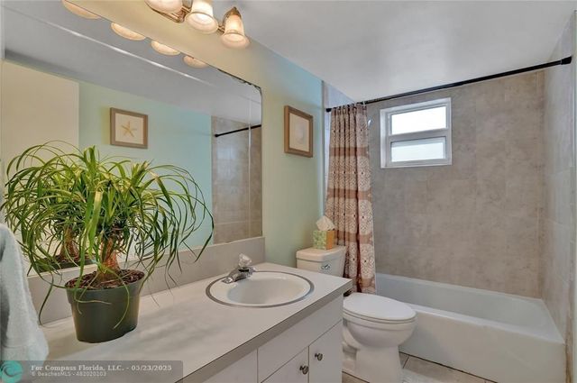 a bathroom with a granite countertop sink a toilet a mirror and shower