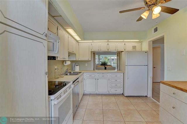 a kitchen with granite countertop a refrigerator and a sink