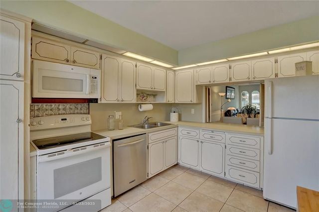 a kitchen with white cabinets and white appliances