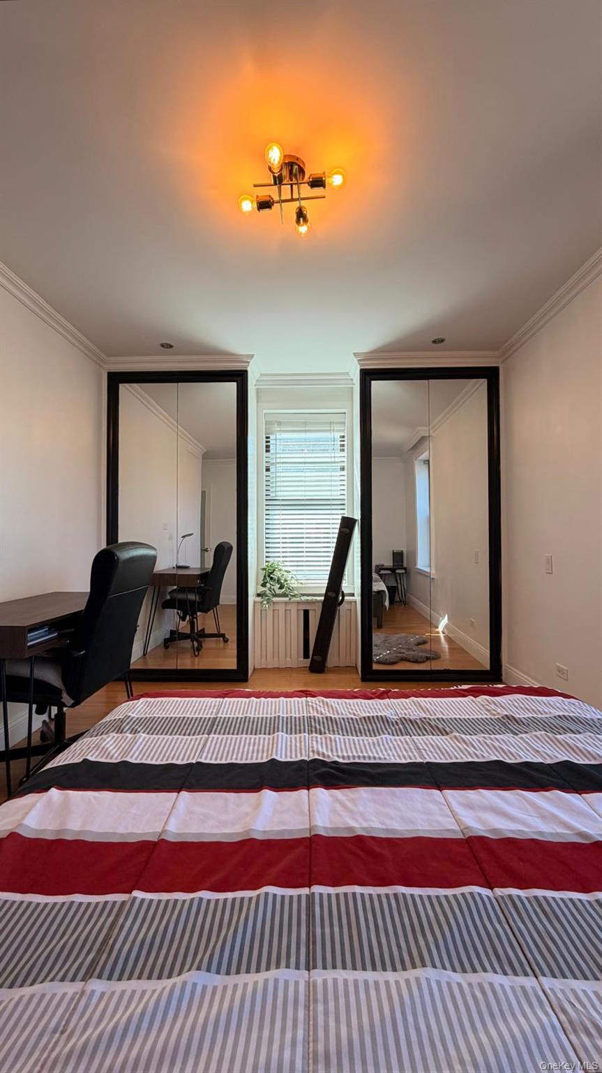 8305 98th Street, Unit 3C Queens, NY 11421 - Photo 6 of 19 a bedroom with a bed and a mirror on dresser