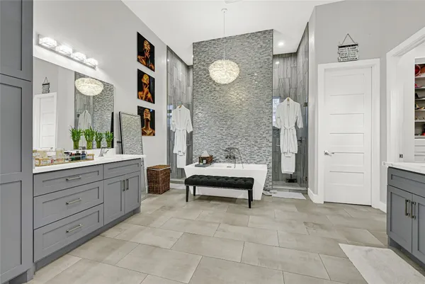 a spacious bathroom with a tub sink and mirror
