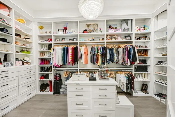 a view of walk in closet with clothes and shoes