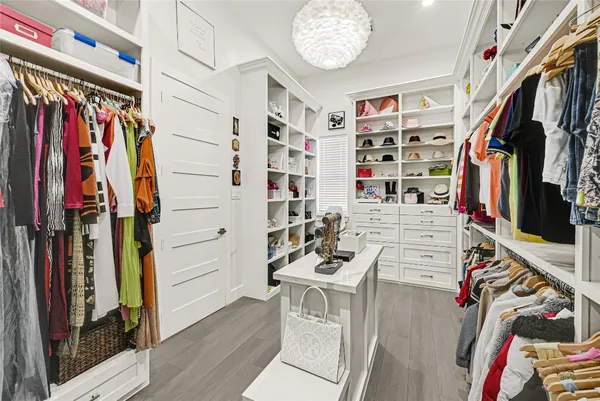a view of walk in closet with clothes and shoes