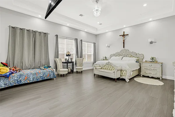 a spacious bedroom with a bed mirror and couch