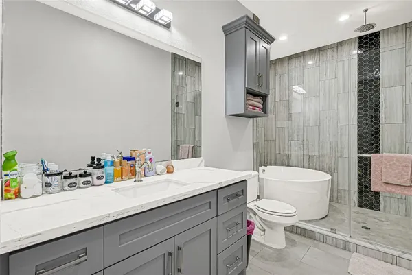 a bathroom with a sink a toilet and shower