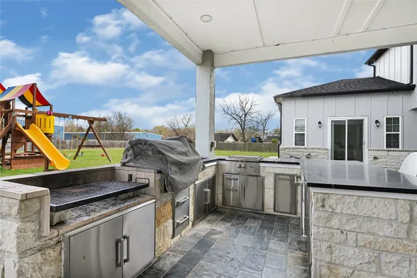 a kitchen with stainless steel appliances granite countertop a stove a sink and a refrigerator