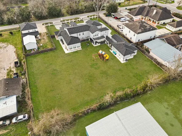 an aerial view of a swimming pool with lawn chairs and large trees