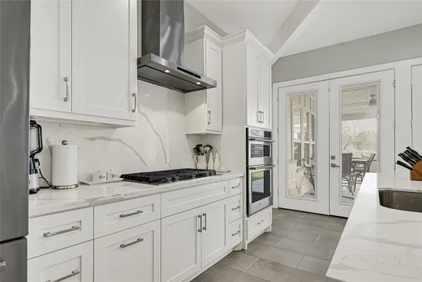 a kitchen with white cabinets and refrigerator