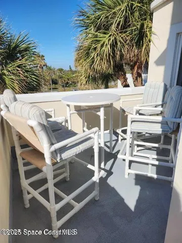 a view of a balcony with chairs and potted plants