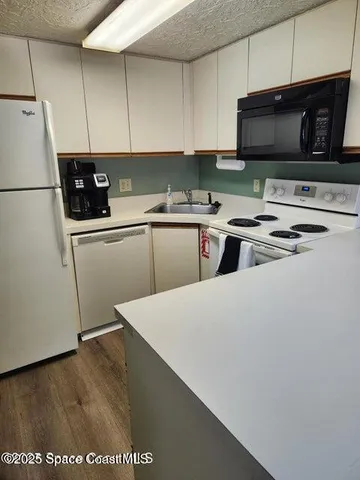a kitchen with stainless steel appliances a stove a microwave a sink and cabinets
