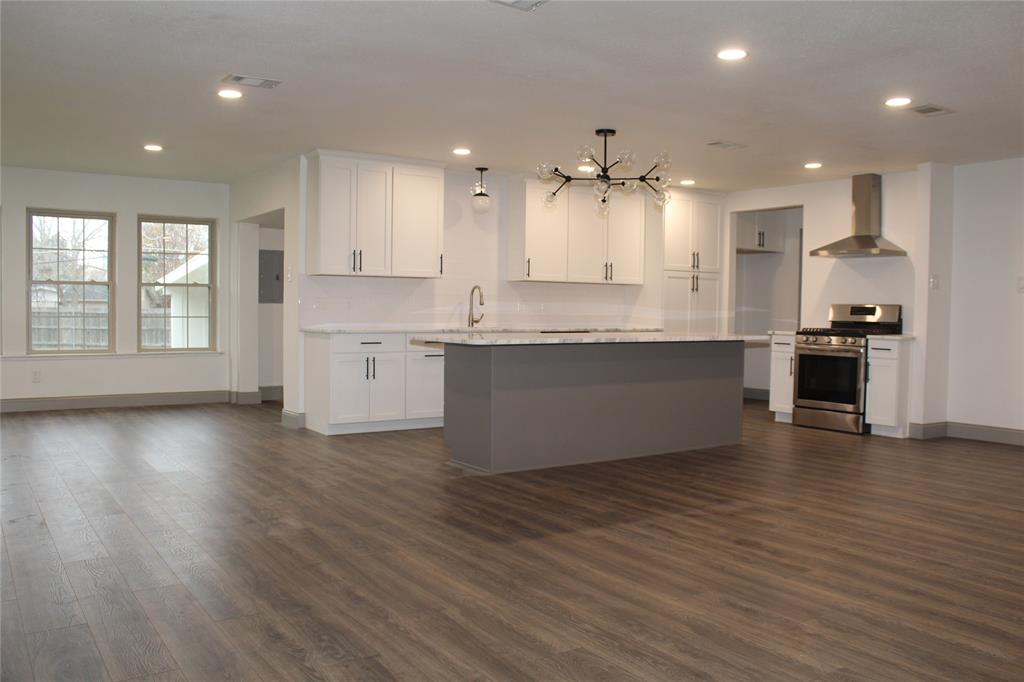 a large kitchen with stainless steel appliances granite countertop a granite counter tops and a wooden floors