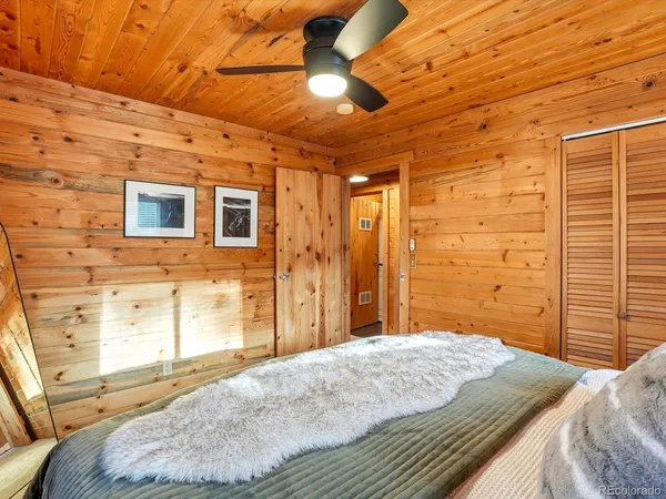 a bedroom with a bed and large windows