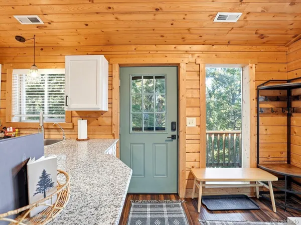 a living room with a floor to ceiling window and wooden floor