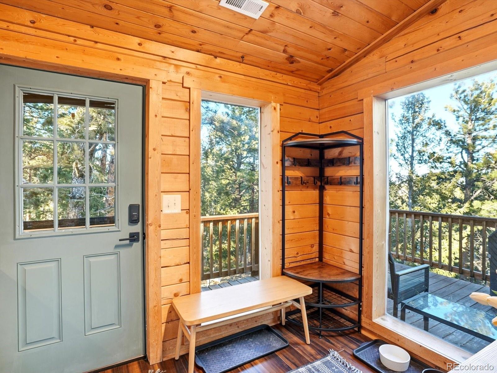 201 Moss Rock Road Bailey, CO 80421 - Photo 9 of 43 a living room with a floor to ceiling window and wooden floor
