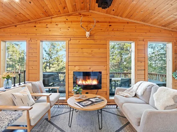 a living room with fireplace furniture and a large window