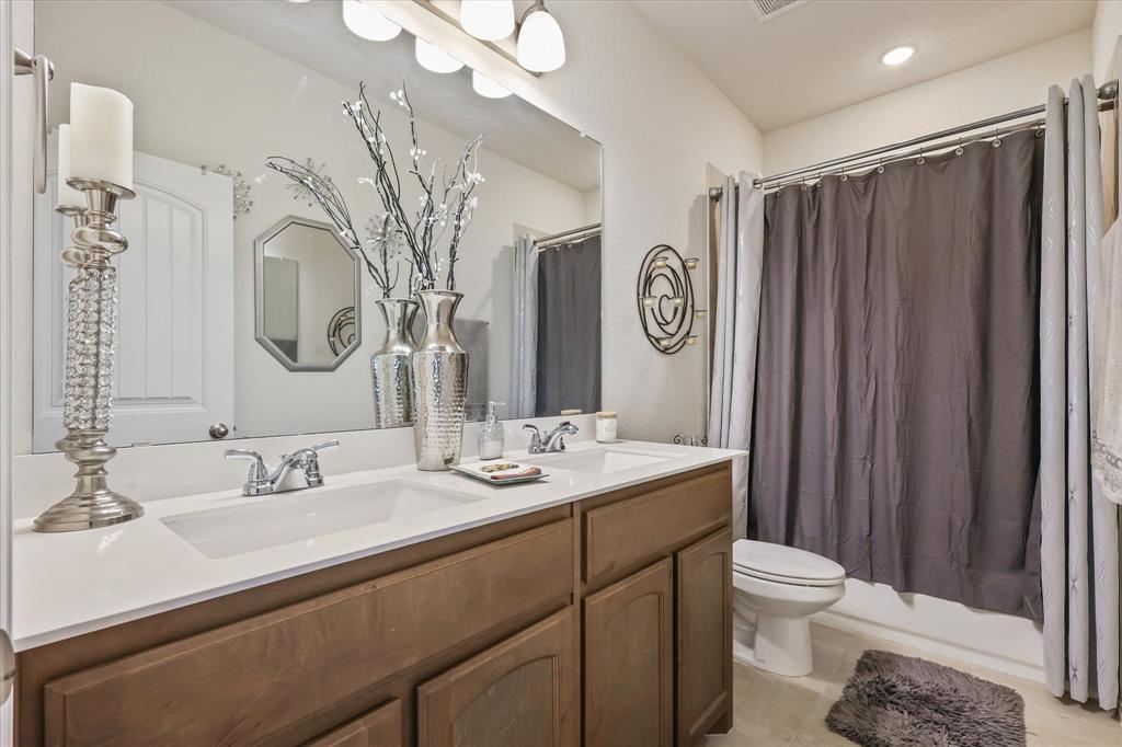 2375 County Road 4010 Decatur, TX 76234 - Photo 10 of 34 Bathroom featuring double vanity, shower / tub combo with curtain, and light tile patterned flooring