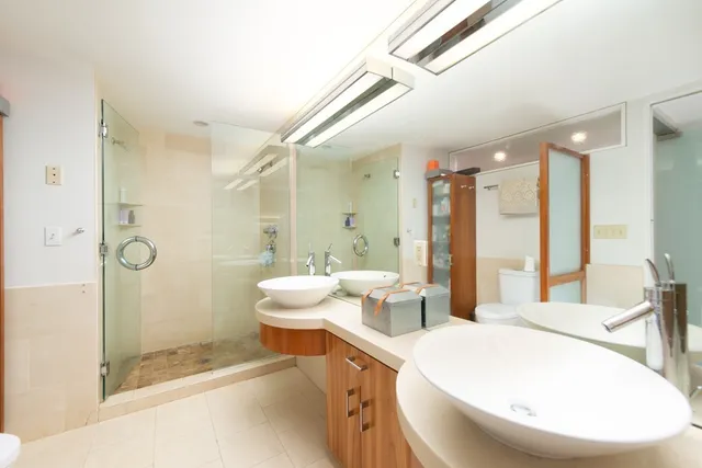 a large white room with a large mirror vanity and toilet