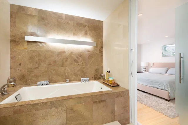 a spacious bathroom with a tub sink and mirror