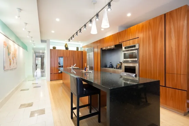 a kitchen with stainless steel appliances a sink cabinets and wooden floor