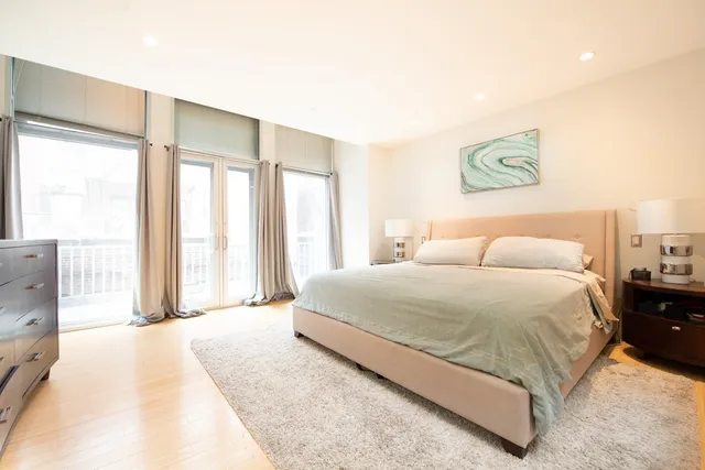 a spacious bedroom with a bed and a large window