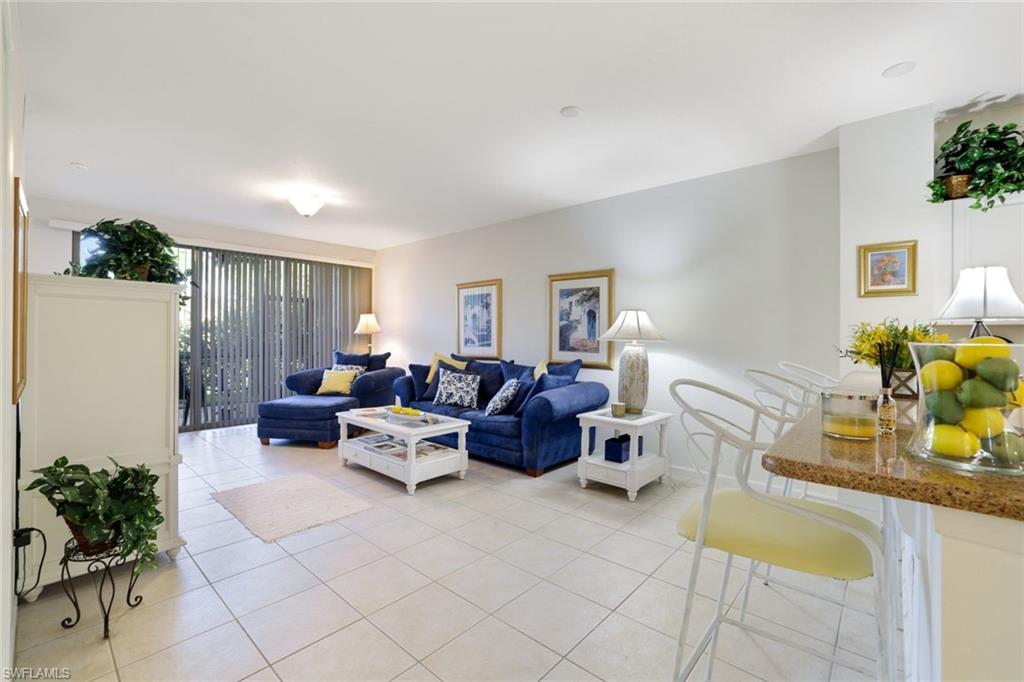 10049 Heather Lane, Unit 101 Naples, FL 34119 - Photo 6 of 28 Living area featuring light tile patterned floors and baseboards