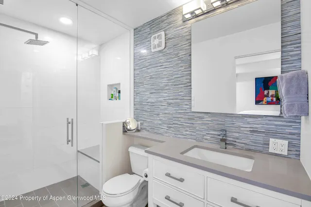 a bathroom with a toilet a sink and shower