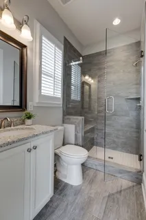 a bathroom with a granite countertop sink toilet and shower