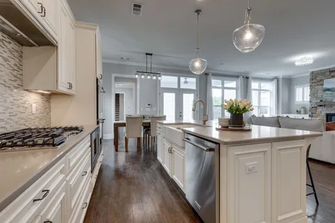 a kitchen with granite countertop cabinets a sink stainless steel appliances and window