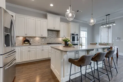 a kitchen with cabinets and chairs