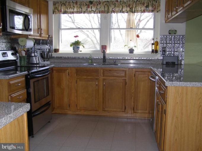 1203 Brookview Road Towson, MD 21286 - Photo 8 of 25 a kitchen with stainless steel appliances granite countertop a stove a sink and a microwave
