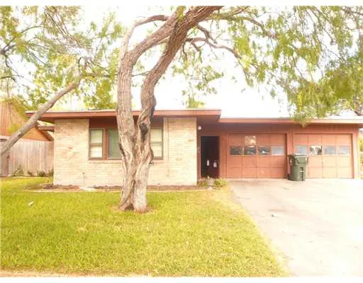 a yellow house with trees in front of it