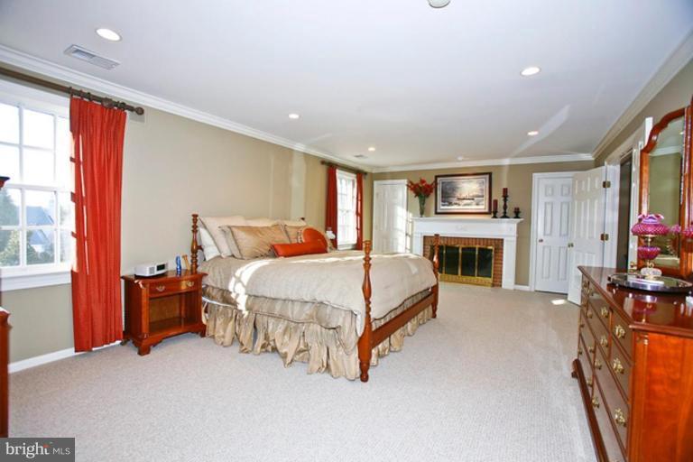 10306 Norton Road Potomac, MD 20854 - Photo 11 of 14 a spacious bedroom with a bed and a fireplace