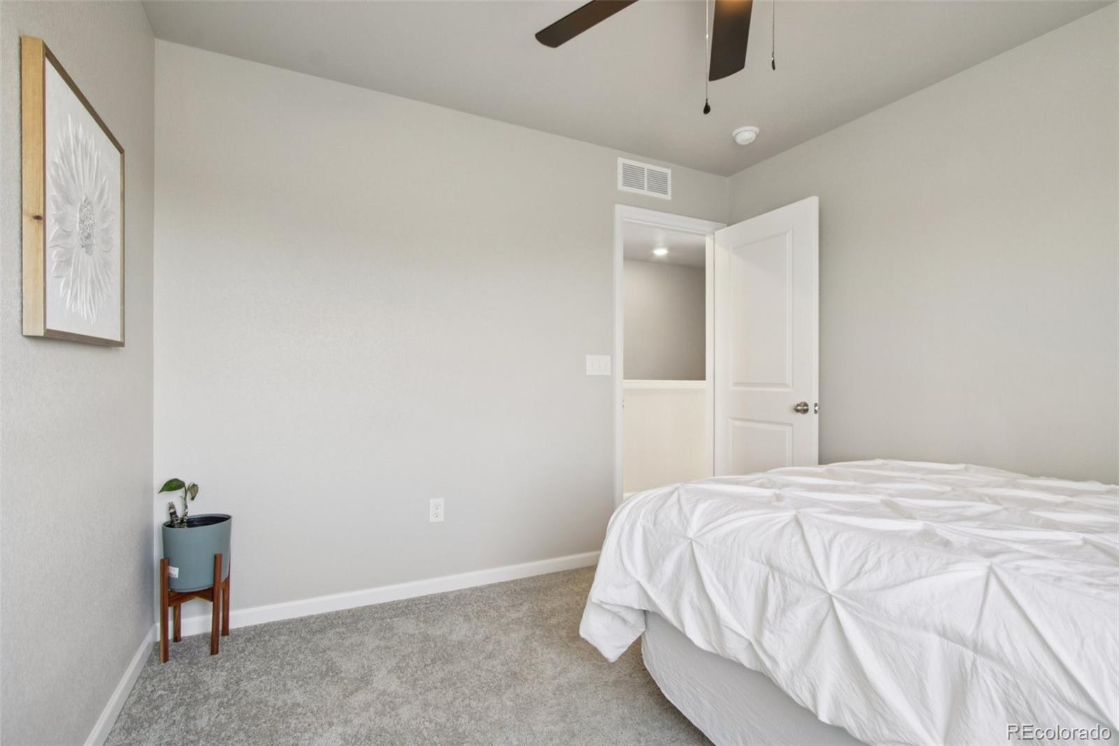 1907 Homestead Drive Fort Lupton, CO 80621 - Photo 22 of 47 a bedroom with a bed and a chandelier