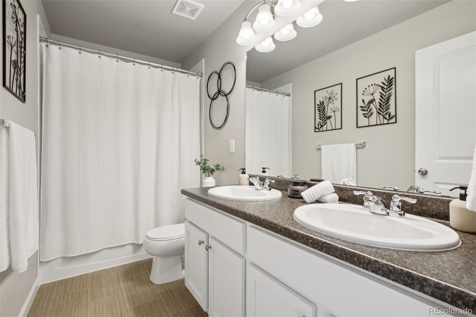 1907 Homestead Drive Fort Lupton, CO 80621 - Photo 23 of 47 a bathroom with a double vanity sink mirror and toilet