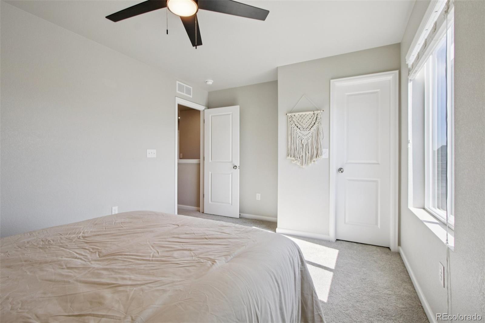 1907 Homestead Drive Fort Lupton, CO 80621 - Photo 25 of 47 a bedroom with a large bed and a chandelier fan