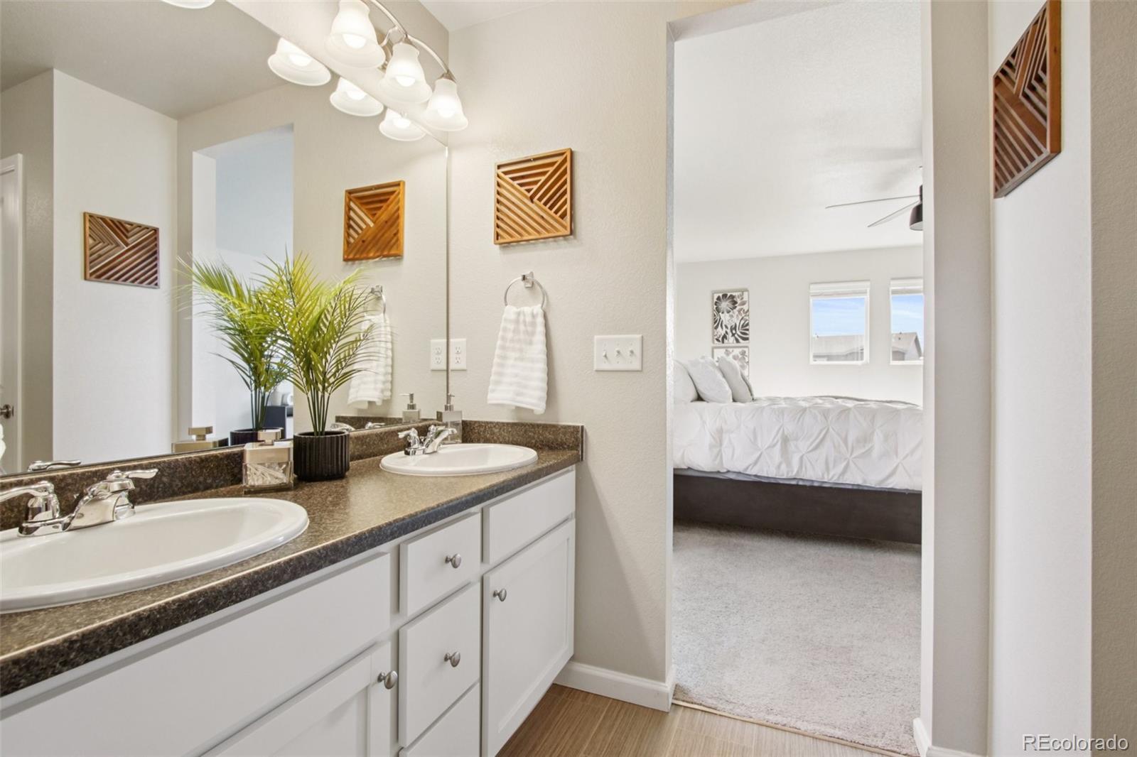 1907 Homestead Drive Fort Lupton, CO 80621 - Photo 31 of 47 a en suite bathroom with double sink and a mirror