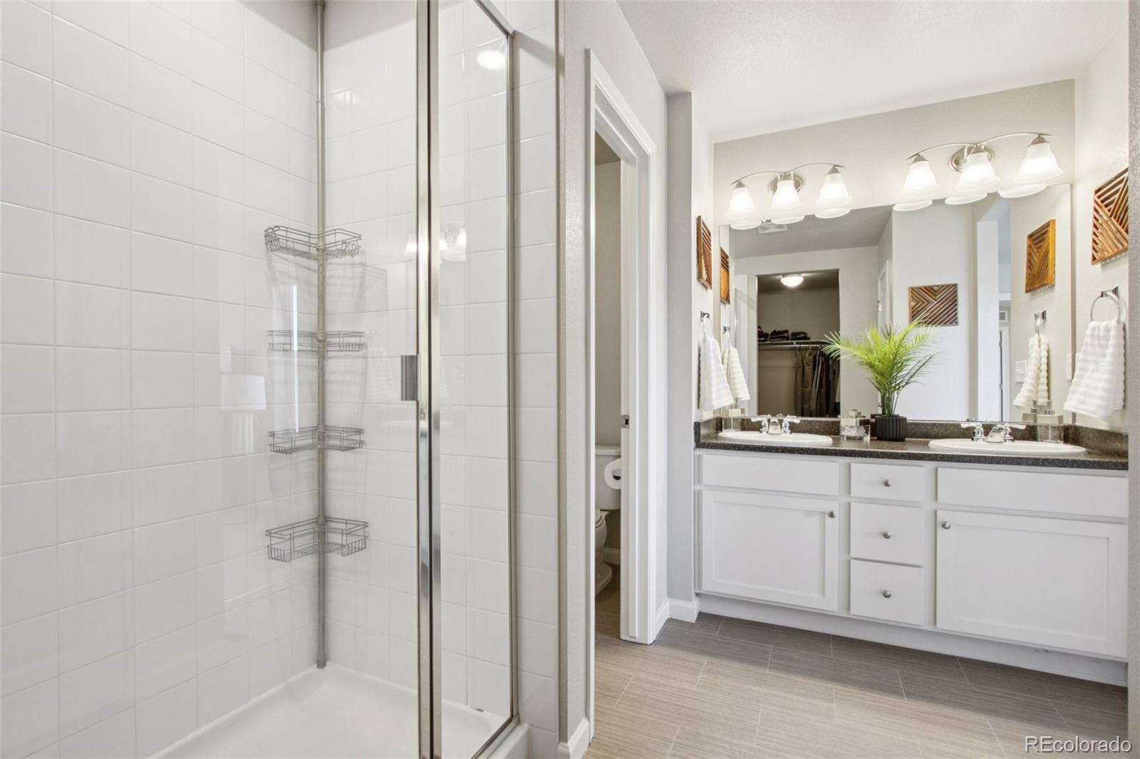 1907 Homestead Drive Fort Lupton, CO 80621 - Photo 32 of 47 a bathroom with a double vanity sink and a mirror