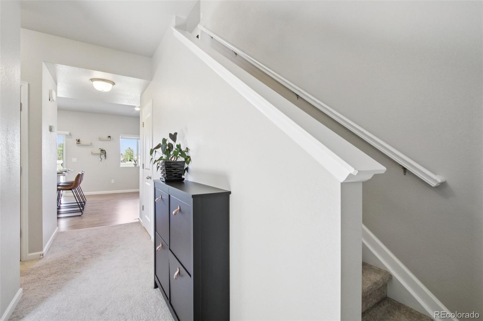 1907 Homestead Drive Fort Lupton, CO 80621 - Photo 4 of 47 a view of a hallway and a livingroom with wooden floor
