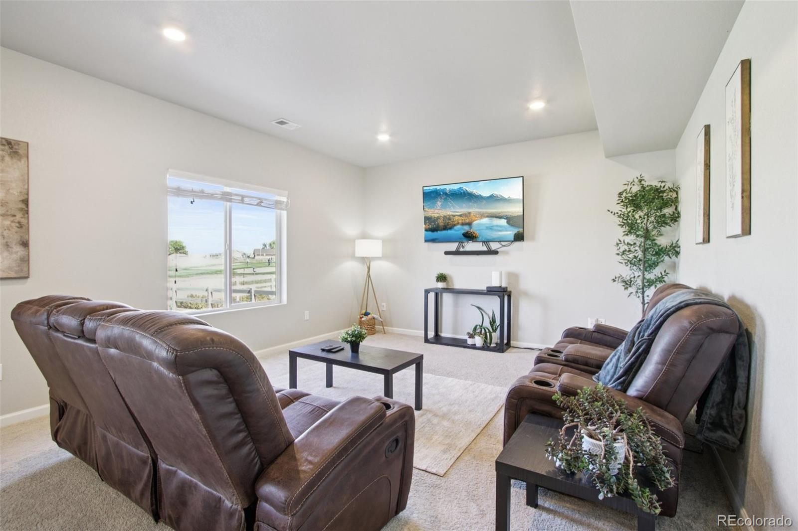 1907 Homestead Drive Fort Lupton, CO 80621 - Photo 7 of 47 a living room with furniture and a flat screen tv