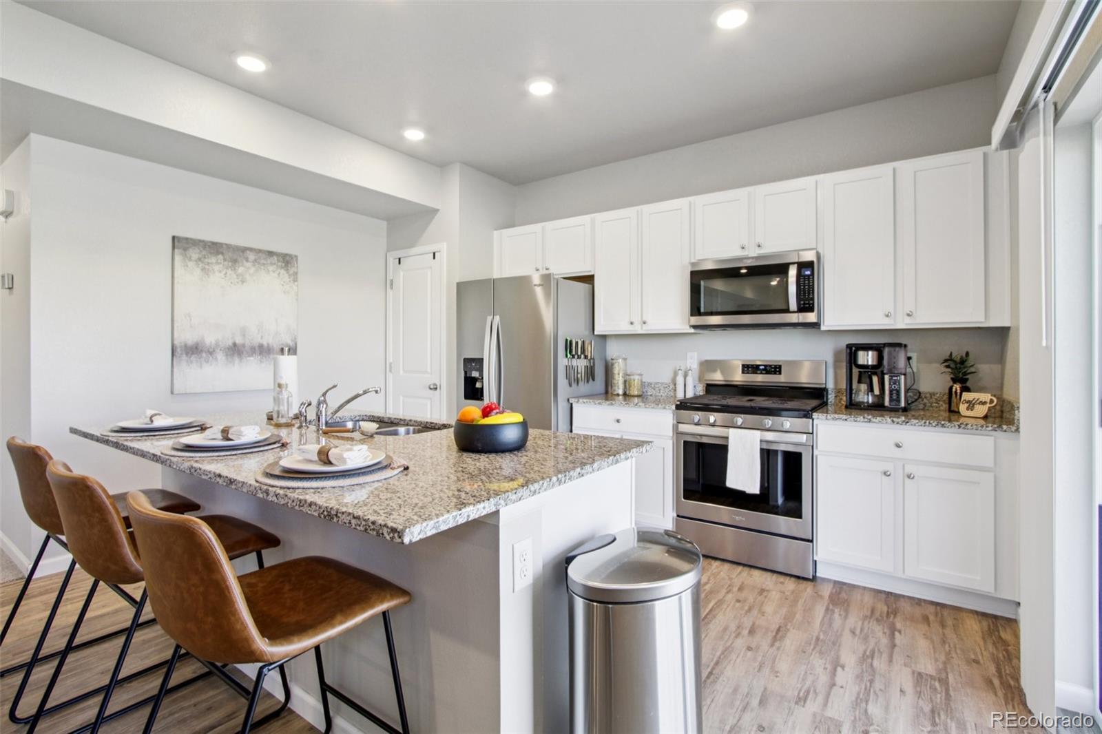 1907 Homestead Drive Fort Lupton, CO 80621 - Photo 9 of 47 a kitchen with a sink cabinets and wooden floor