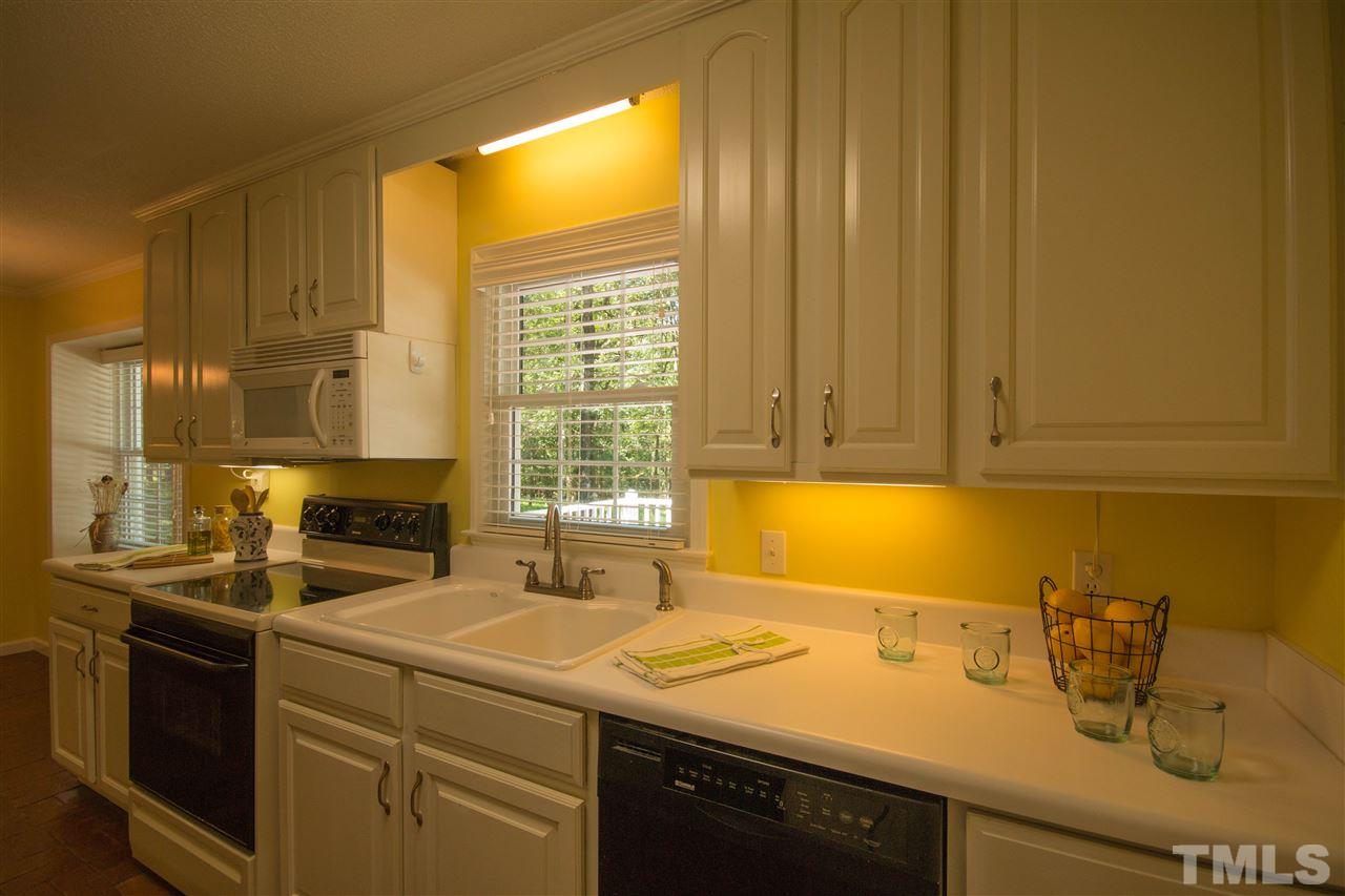 7626 Herndon Road Durham, NC 27713 - Photo 11 of 25 The electric range/oven has a smooth top with a microwave above. The appliances add sleek black accents to the space.