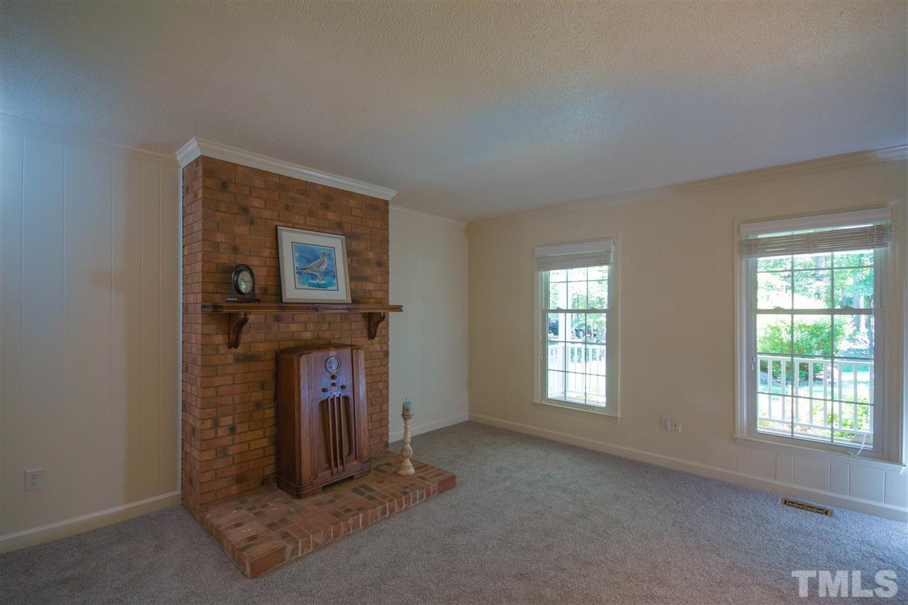 7626 Herndon Road Durham, NC 27713 - Photo 8 of 25 Has brick fireplace surround and hearth that was once home to a wood stove. Windows overlook front porch.
