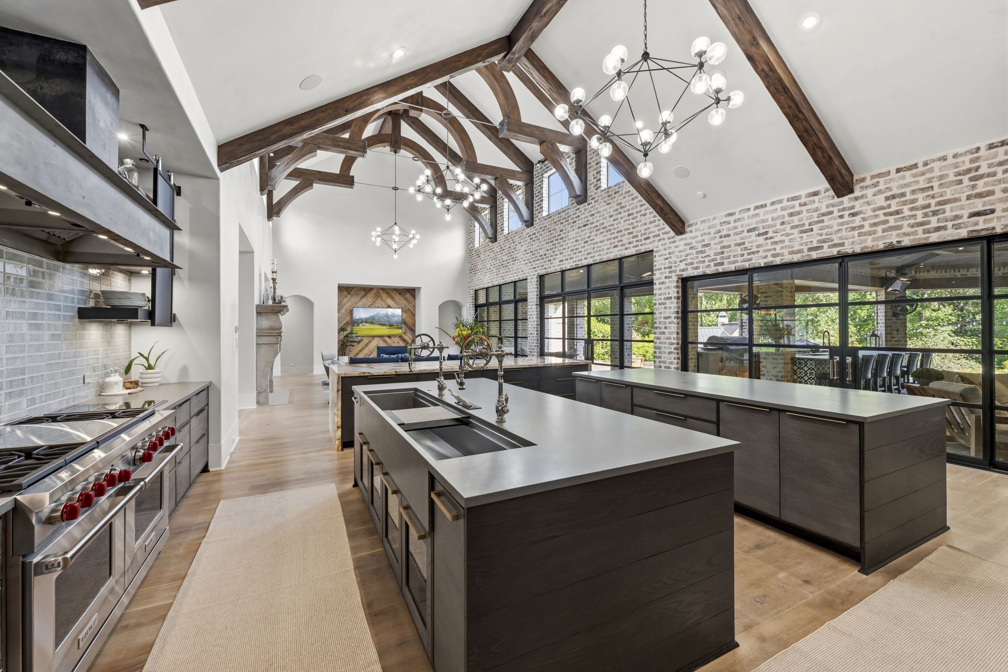 27006 Star Gazer Way Spring, TX 77386 - Photo 13 of 50 A chef’s dream kitchen featuring three islands, flush-front custom cabinetry, quartz countertops, modern hardware, abundant storage, and a stunning backlit Patagonia granite island.